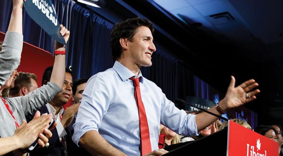 Man stands on stage waving to supporter