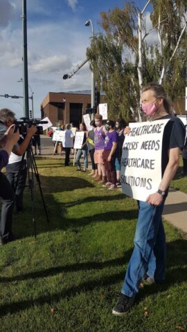Lethbridge SCS Rally 5 A protester holding a sign being interviewed by the media