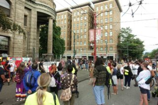 Crowd of people gathered outside Carnegie Centre at the corner of Main and Hastings