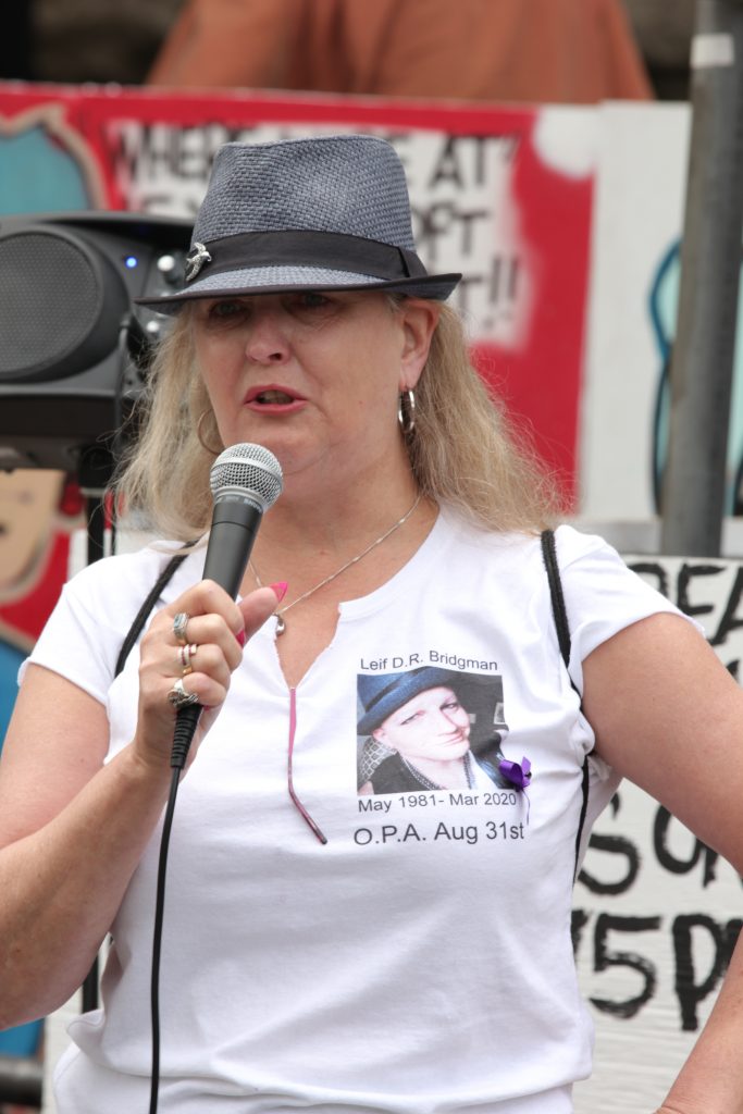 A woman speaking on a microphone on International Overdose Awareness Day