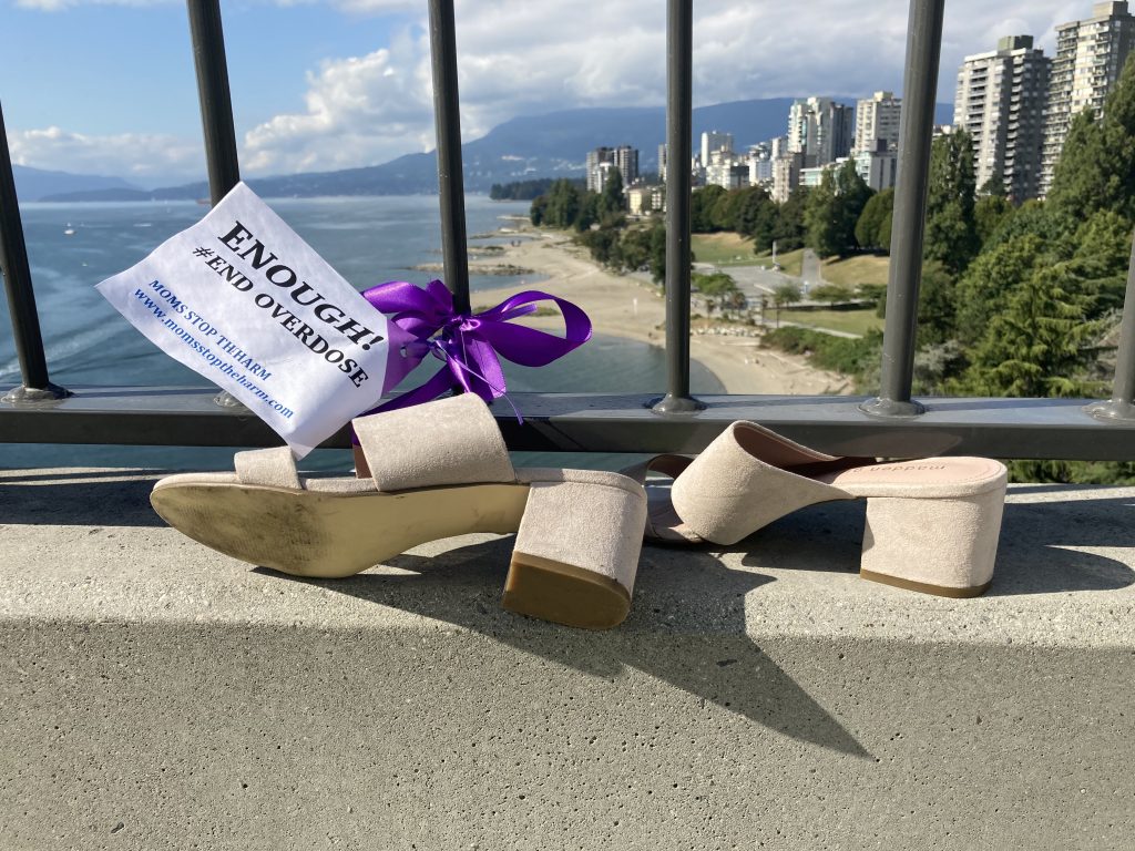 Pair of shoes tied to Burrard Street Bridge with a purple ribbon