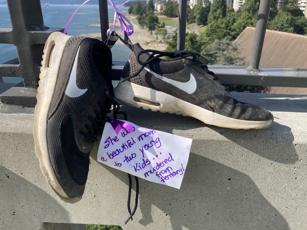 A pair of shoes tied to Burrard Street Bridge with a note