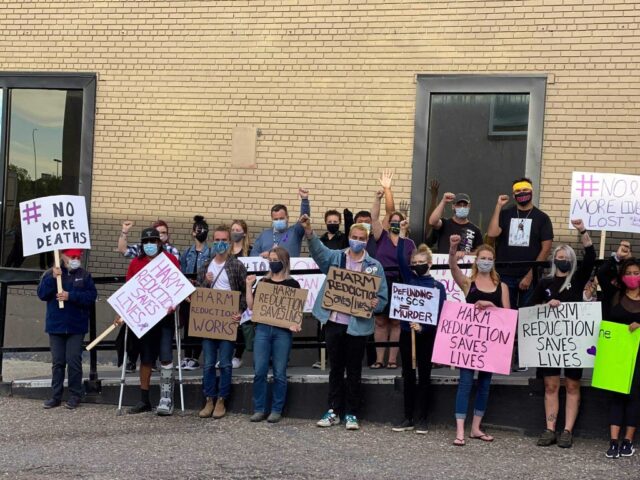 Lethbridge SCS Rally 2 People holding signs with arms raised