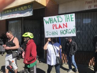 Person holding a protest sign at a rally