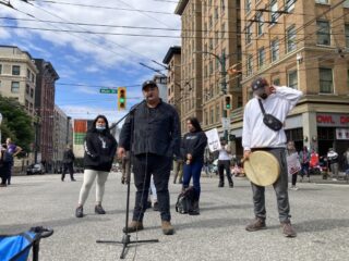 A person on a microphone speaking at a rally and protest
