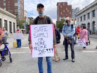A man wearing a white sign at a rally