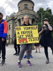 A woman holding a yellow sign at a rally