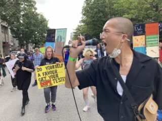 An Asian male yelling into a microphone
