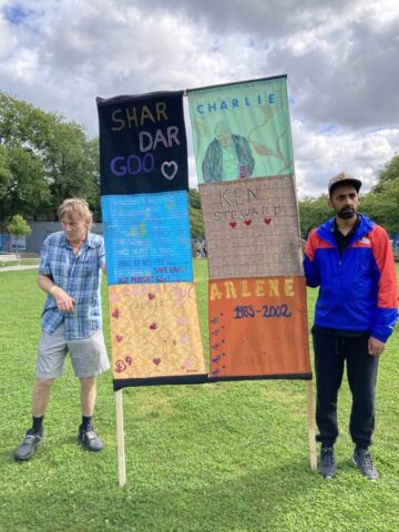 19 Two people holding a sign made of quilts