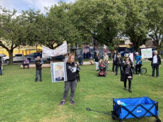A woman speaking on a microphone to a crowd