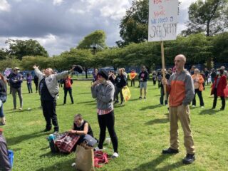 Protester and supporters holding signs at a rally