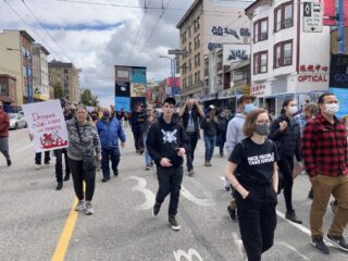 Crowd of people walking down a street